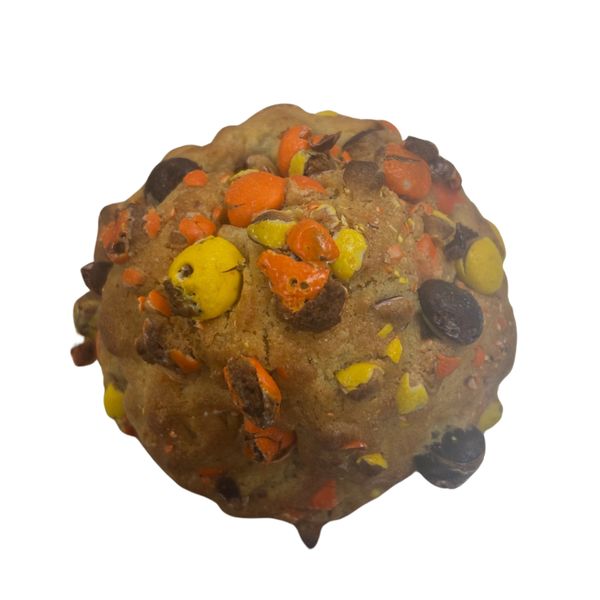 A light brown cookie with yellow and orange candy on outside